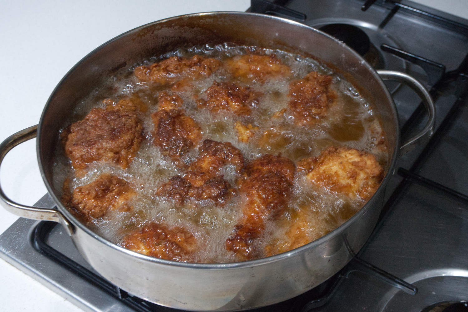 Frying the chicken until golden brown.